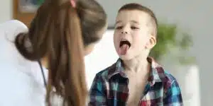 Blister i munden. Lille dreng der viser sin mor sin mund.